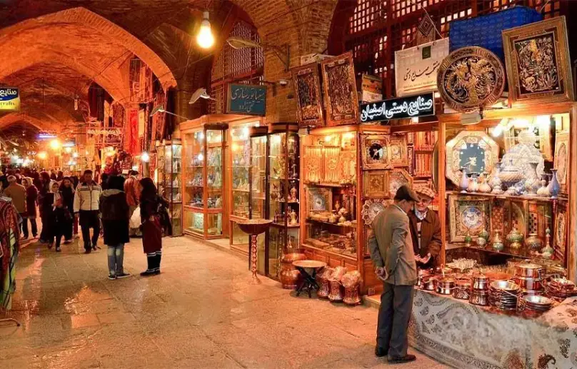 بازار قیصریه اصفهان با غرفههای صنایع دستی مسی، میناکاری و خاتمکاری در فضایی سنتی و پرنور